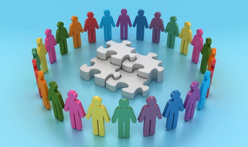 Colourful blocks of people standing in a circle around a white puzzle piece.