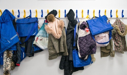 Image of schoolbags and jackets on school hangers. 