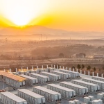 A battery storage plant in the desert with sun above. 