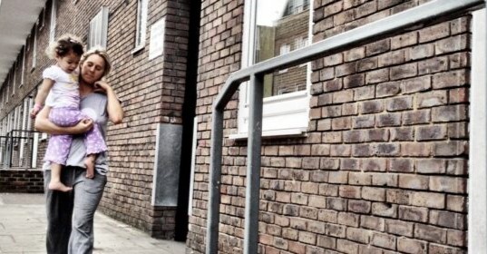 Woman carrying child in a deprived neighbourhood.