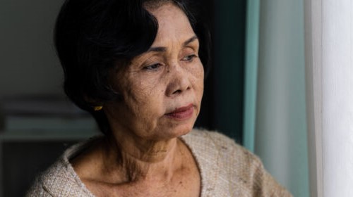 Woman of ethnic origin looking out the window