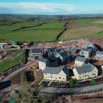 A housing construction site surrounded by green rural countryside. 