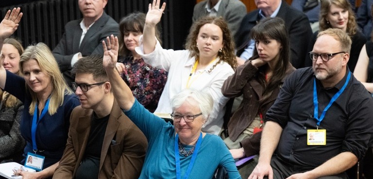 Image of audience members raising their hands to ask a question at Policy@Manchester panel event at Conservative Party Conference 2025.